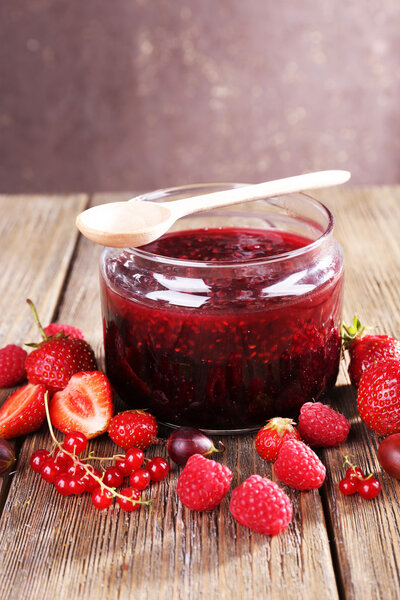 Ягодное варенье в стеклянной банке на столе, крупным планом
