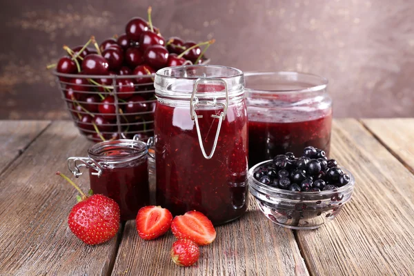 Jam in glazen pot op tafel, bessen close-up — Stockfoto