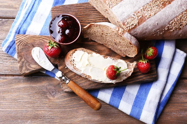 新鮮な自家製のバターとジャム付きトースト イチゴ木製の背景に — ストック写真
