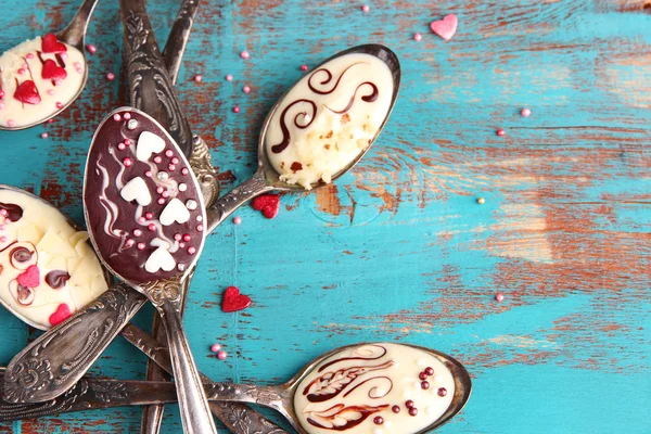 Spoons with tasty chocolate for party on old blue wooden table — Stock Photo, Image