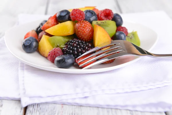 Läcker fruktsallad i tallrik på bordet närbild — Stockfoto