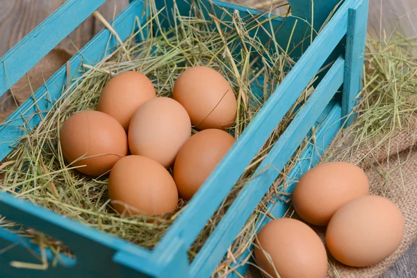 Eieren in houten doos op tabel close-up — Stockfoto