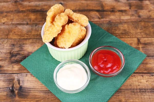 Kipnuggets met sauzen op tabel close-up — Stockfoto