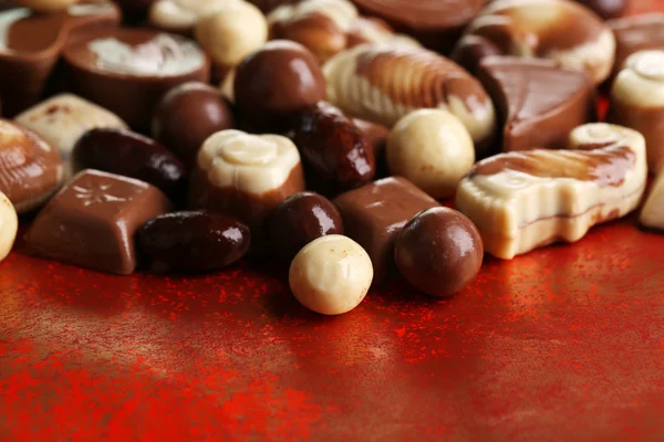 Olika sorters choklad på röd bakgrund — Stockfoto