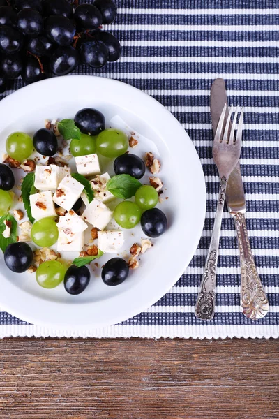 Gustosa insalata con uva e formaggio sul tavolo di legno — Foto Stock