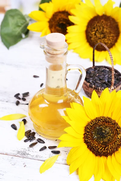 Sunflowers with seeds and oil on table close-up — Stock Photo, Image