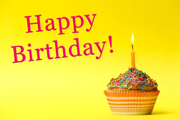 Delicious birthday cupcake on yellow background — Stock Photo, Image
