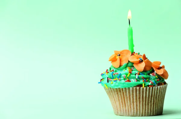 Delicioso cupcake de cumpleaños sobre fondo verde claro — Foto de Stock