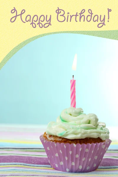 Delicioso cupcake de aniversário na mesa no fundo azul claro — Fotografia de Stock