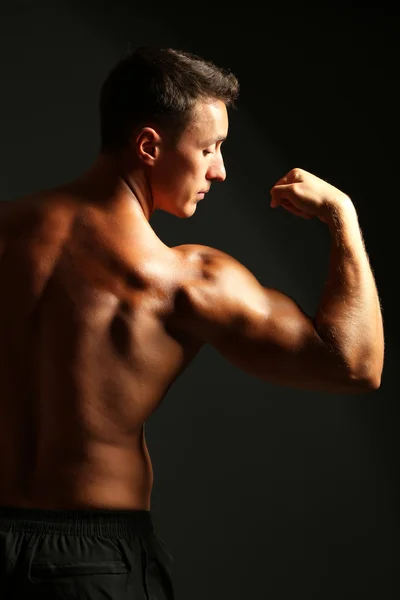 Handsome muscle young man on dark background — Stock Photo, Image