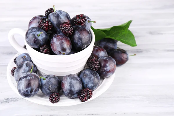 Ripe sweet plums in big cup — Stock Photo, Image