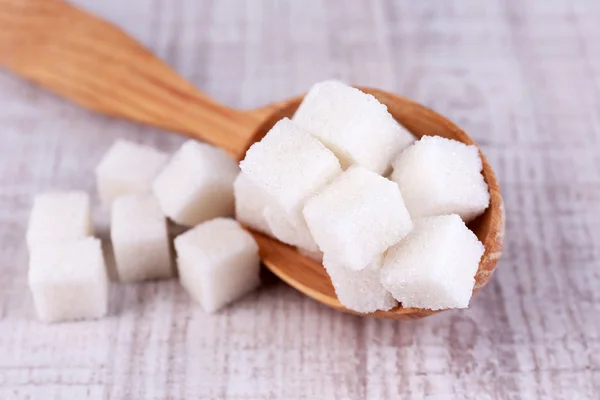 Azúcar blanco refinado en cuchara de madera sobre fondo de madera —  Fotos de Stock