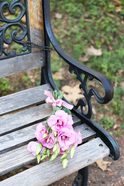 Mooi boeket van eustoma bloemen op houten bank in park — Stockfoto