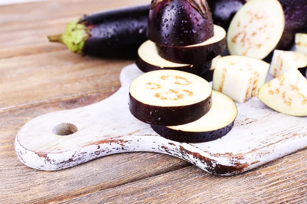 Aubergines hachées sur planche à découper sur fond bois — Photo