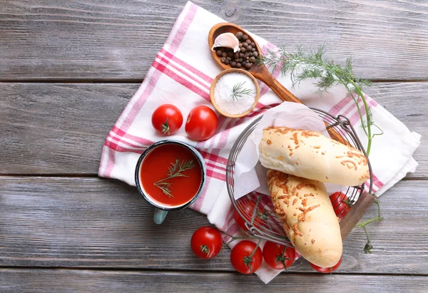 Jugo de tomate casero en taza de color, palitos de pan, especias y tomates frescos sobre fondo de madera — Foto de Stock