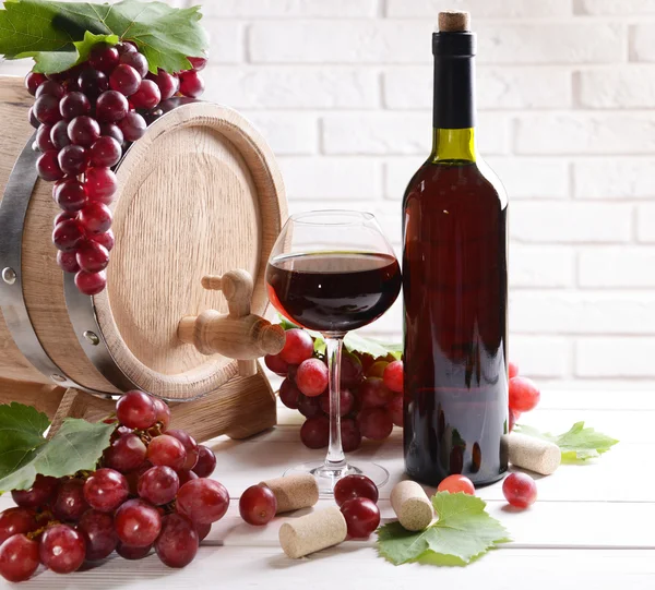 Wijn met druiven op tafel op bakstenen muur achtergrond — Stockfoto