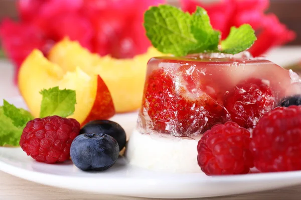 Gâteau à la gelée de fraises avec fruits et baies sur assiette sur fond en bois — Photo