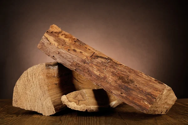 Heap of firewood on floor on dark background — Stock Photo, Image