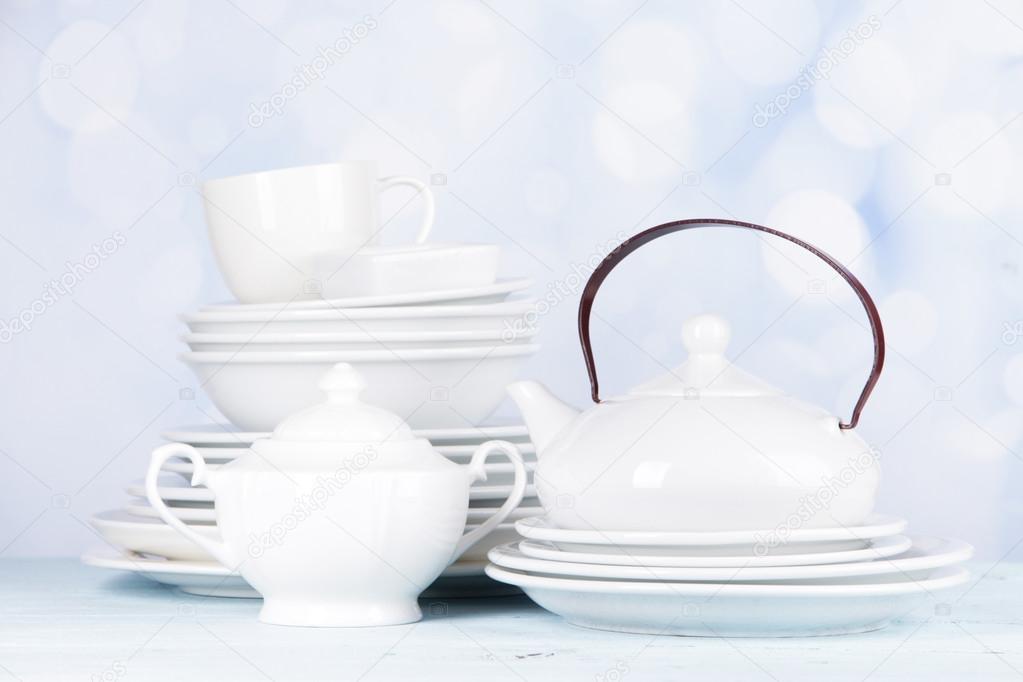 White crockery and kitchen utensils, on light background