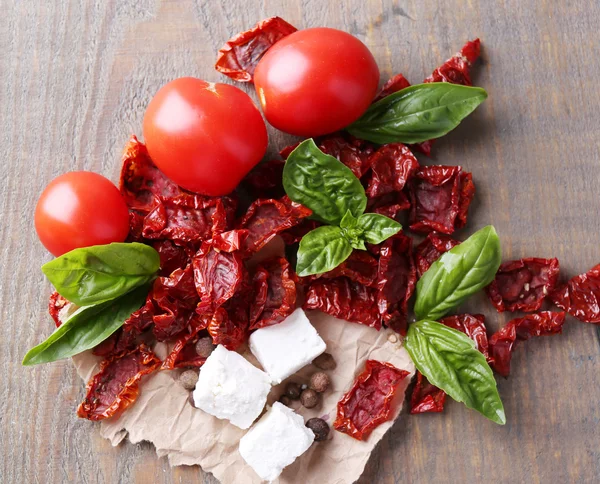 태양 건조 및 신선한 토마토, 바 질 잎, feta 치즈 색 나무 배경 — 스톡 사진