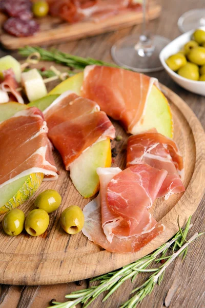 Delicious melon with prosciutto on table close-up — Stock Photo, Image