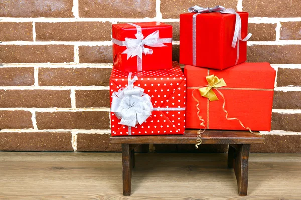 Presentes de Natal nas fezes no fundo da parede de tijolo marrom — Fotografia de Stock