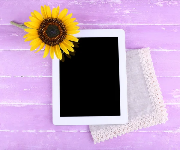 Tablette und Sonnenblume auf Serviette auf Holzgrund — Stockfoto