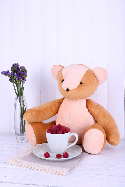 장난감 곰 및 나무로 되는 벽 바탕에 냅킨에 나무 딸기의 컵 — 스톡 사진