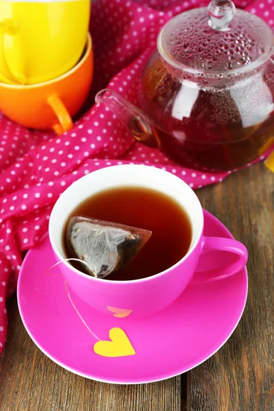 Cup of tea, teapot and tea bags on wooden table close-up — Stock Photo, Image