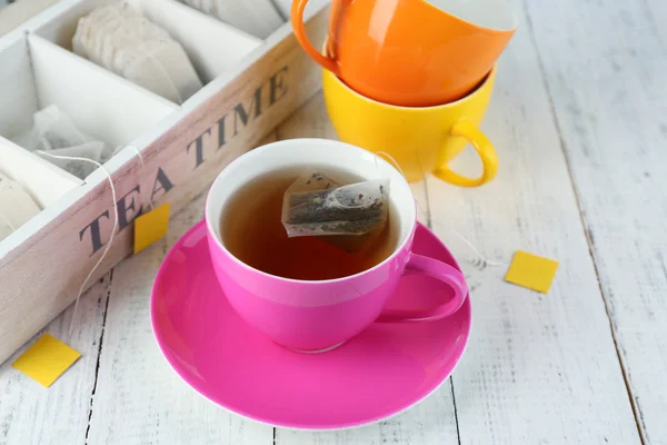 Tasse mit Tee- und Teebeutel auf Holztisch in Großaufnahme — Stockfoto