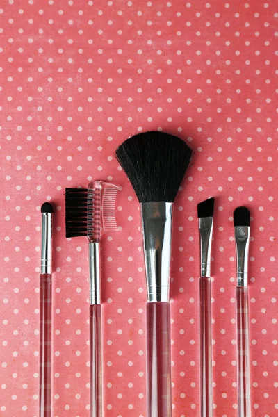 Cepillos para maquillaje sobre fondo rosa —  Fotos de Stock