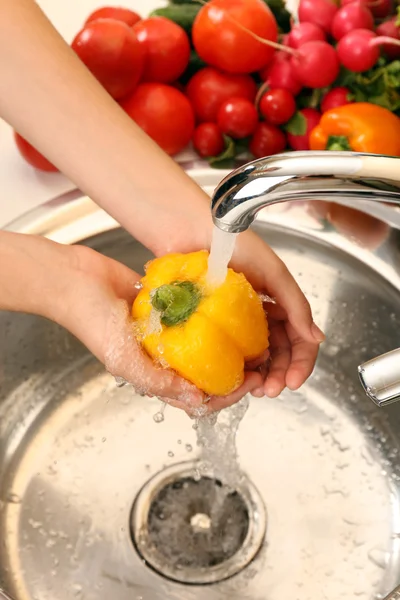 Woman's hands washing pepper — Stock Photo, Image