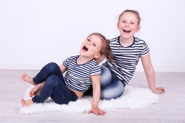 Duvar zemin katta oturan güzel küçük kızlar