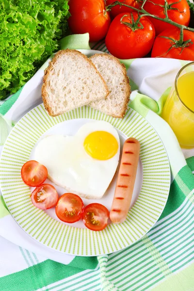 Scrambled eggs with sausage and vegetables served on plate on fabric background — Stock Photo, Image