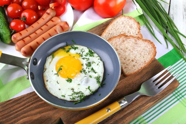 Scrambled egg with sausage and vegetables served on pan on cutting board — Stock Photo, Image