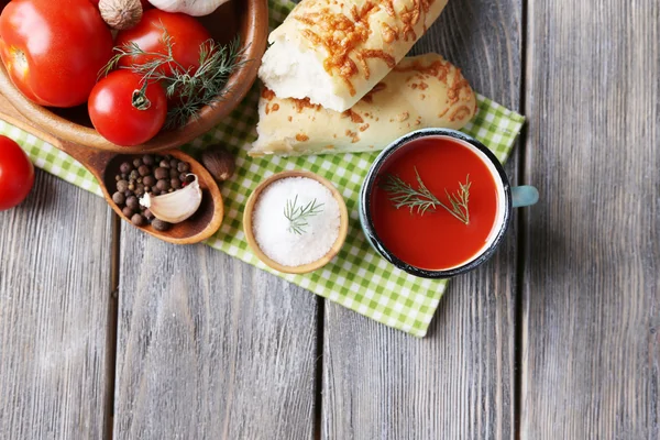 Jugo de tomate casero en taza de color, palitos de pan, especias y tomates frescos sobre fondo de madera — Foto de Stock