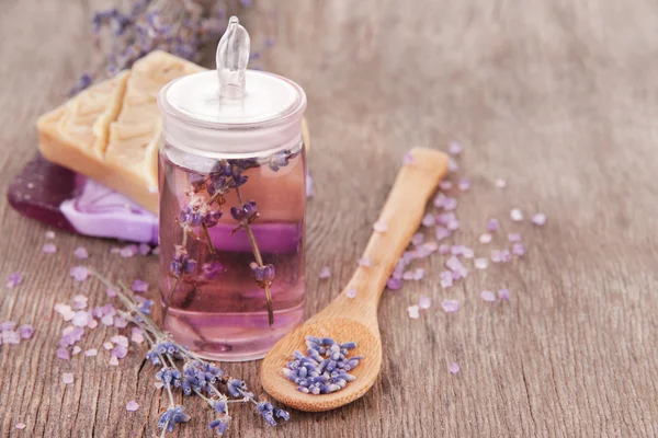 Natura morta Spa con olio di lavanda e fiori su tavola di legno — Foto Stock