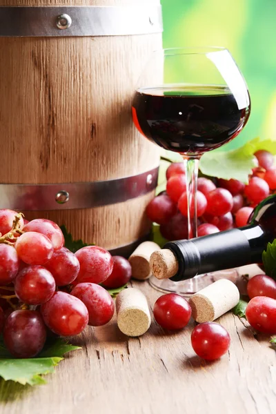 Vino con uvas sobre mesa sobre fondo brillante — Foto de Stock