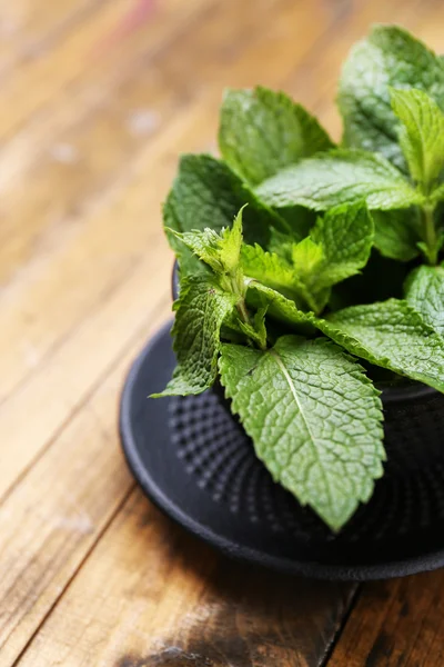 Mangkuk tradisional Cina untuk teh dengan daun mint di latar belakang kayu — Stok Foto