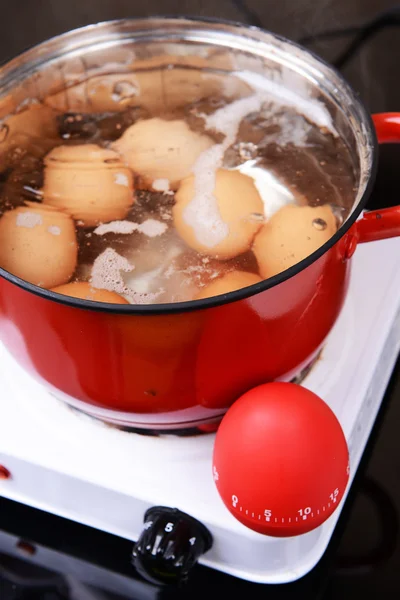 Яйца в кипятке в кастрюле на электрической плите — стоковое фото