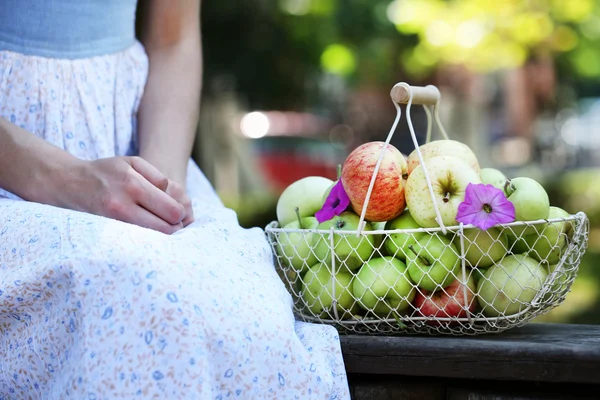 Mädchen und Korb mit Äpfeln im Freien — Stockfoto