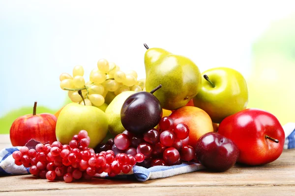 Asortyment soczyste owoce w serwetkę, na stole, na jasnym tle — Zdjęcie stockowe