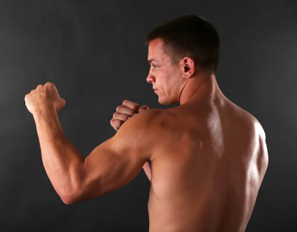 Bello giovane sportivo muscoloso boxe su sfondo scuro — Foto Stock