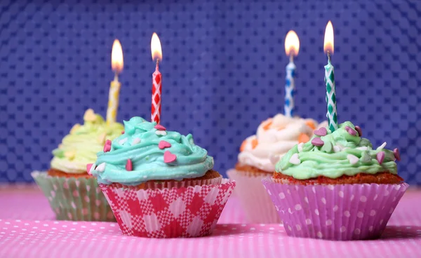 Delicious birthday cupcakes on table on purple background — Stock Photo, Image