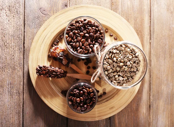 Kaffeebohnen in Gläsern auf Bambusteller auf Holzgrund — Stockfoto