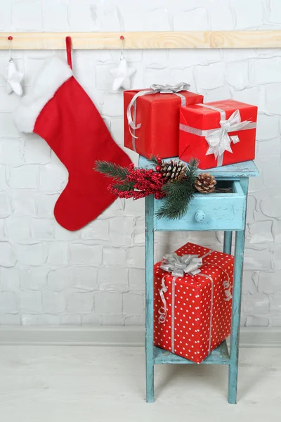 Christmas presents on blue bookcase on brick wall background — Stock Photo, Image