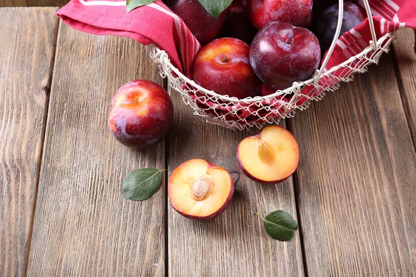 Sweet plums in wicker basket — Stock Photo, Image