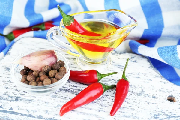 Set of spices and olive oil in glass sauce-boat, in cutting board, on color  wooden background — Stock Photo, Image