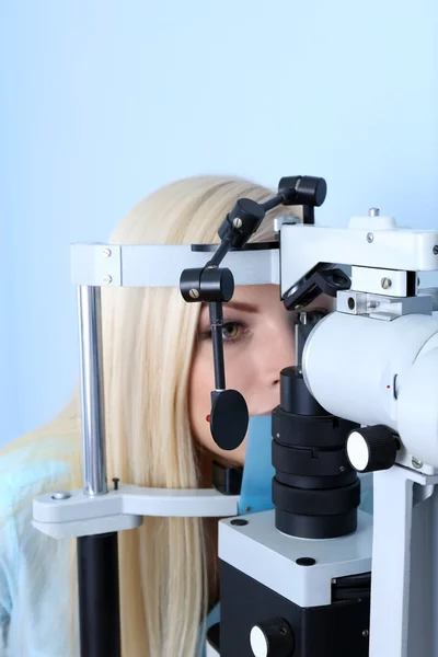 Концепция оптометрии - красивая молодая женщина, глаза которой осматривает окулист — стоковое фото