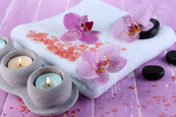 Orchideebloemen, spa stenen, kaarsen en handdoek — Stockfoto